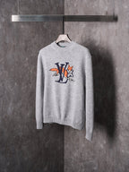 Light gray knit sweater with crew neck and multicolor graphic cartoon logo on chest