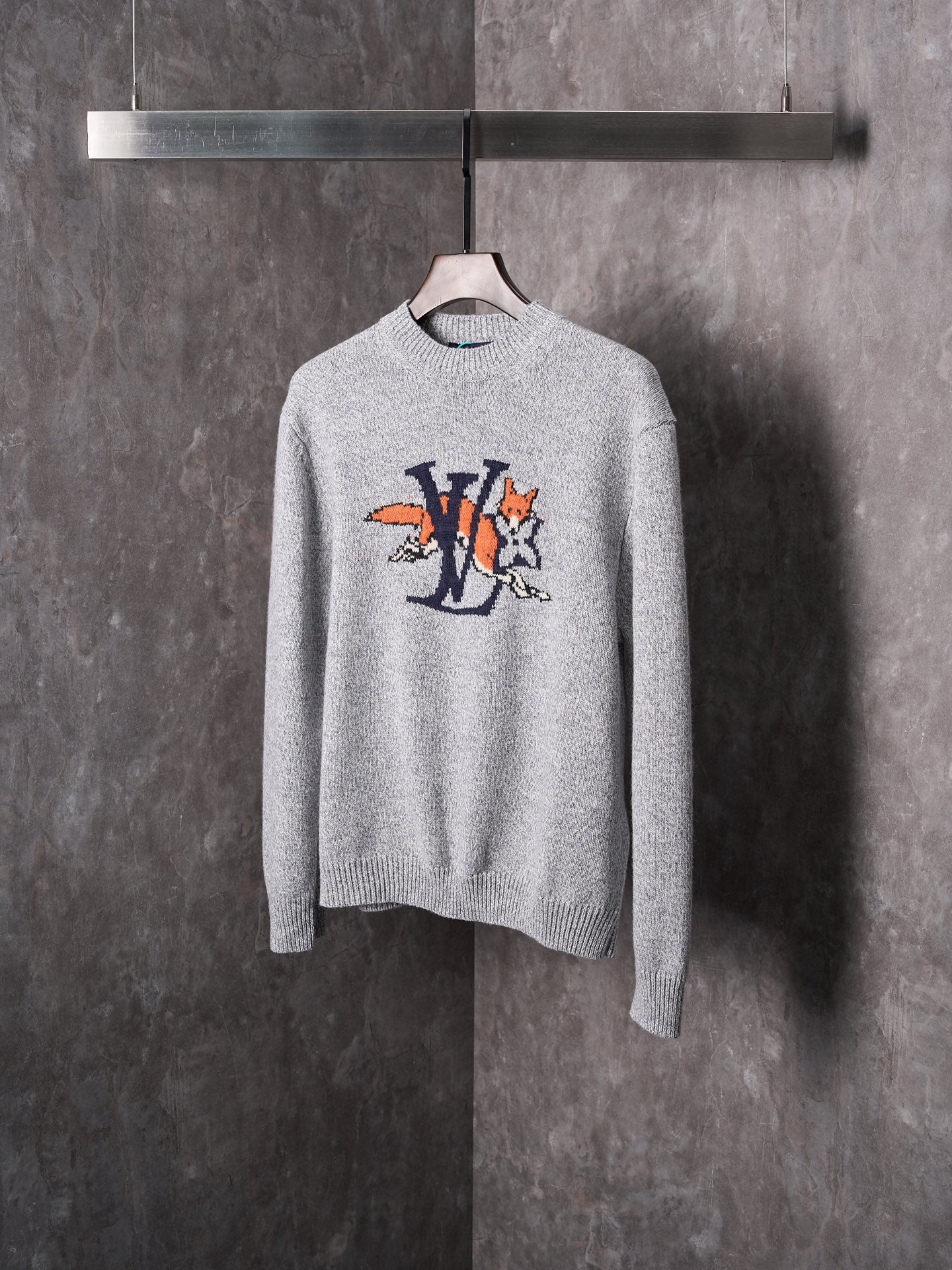 Light gray knit sweater with crew neck and multicolor graphic cartoon logo on chest