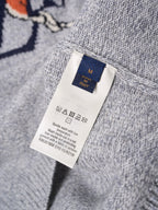 Light gray knit sweater size care tag with “M” and “Italy” on label