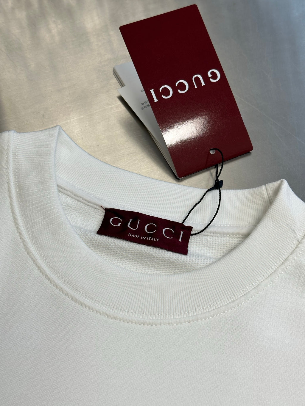 White Gucci sweatshirt neckline with Gucci tag and size label
