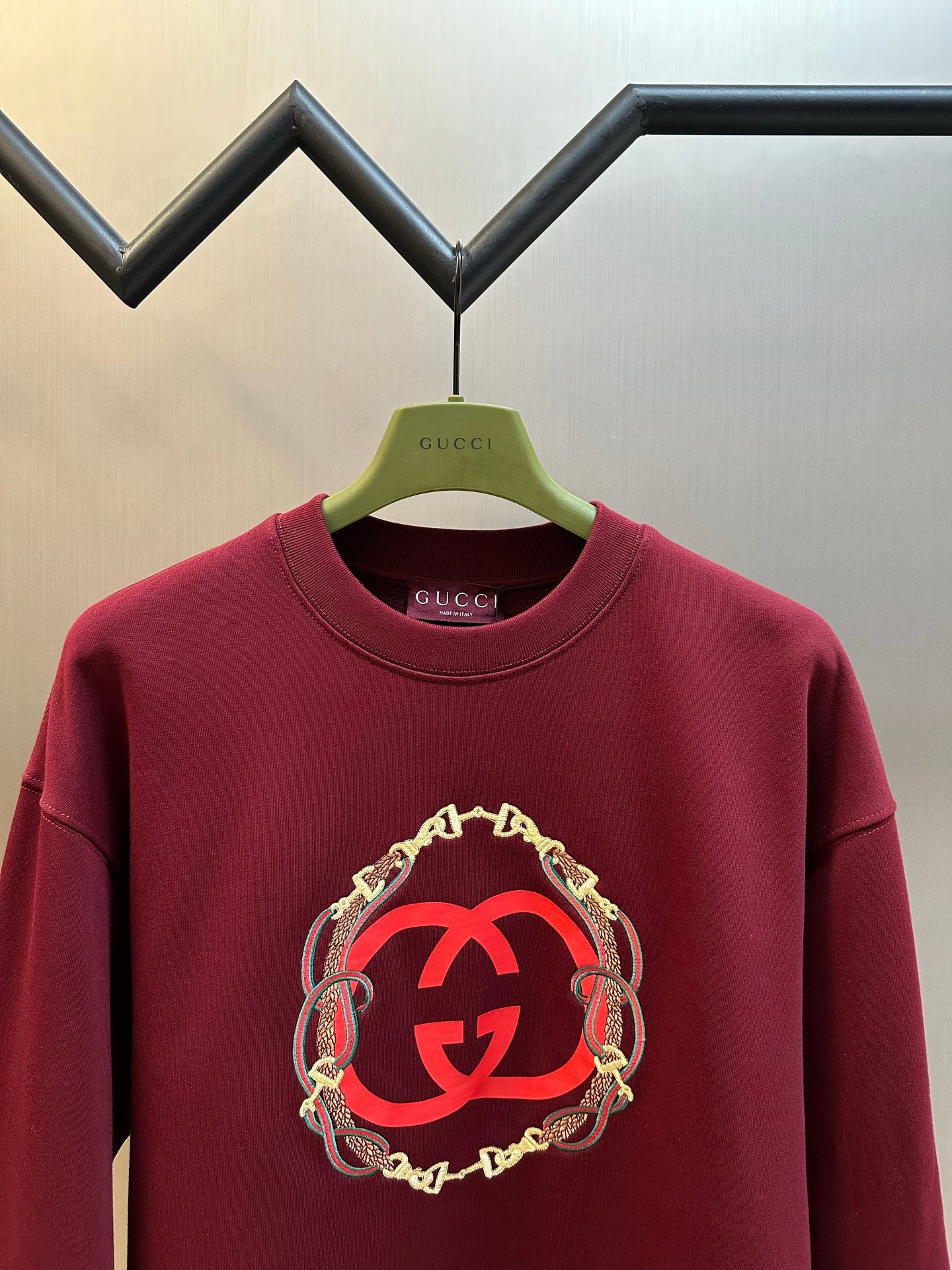 Maroon Gucci crewneck sweatshirt with red GG logo and gold chain trim, front view