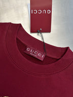 Maroon crewneck sweatshirt with ribbed neckline and Gucci label at collar