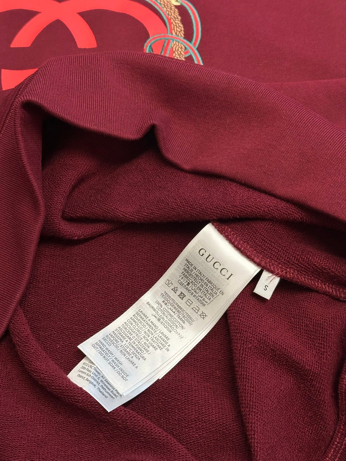 Maroon sweatshirt with inner care label attached inside neckline area