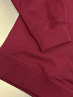 Maroon sweatshirt sleeve cuff and curved hem stitching detail