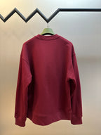 Maroon crewneck sweatshirt, plain back view with ribbed collar and cuffs