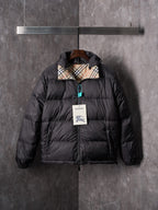 Black puffer jacket with attached hood and full front zip, teal zipper pull detail.