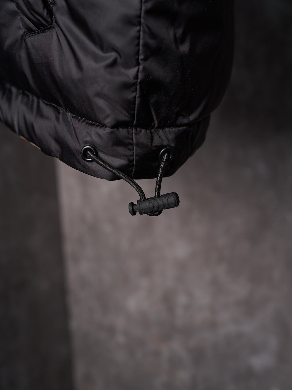Black long puffer jacket hem with drawstring toggle
