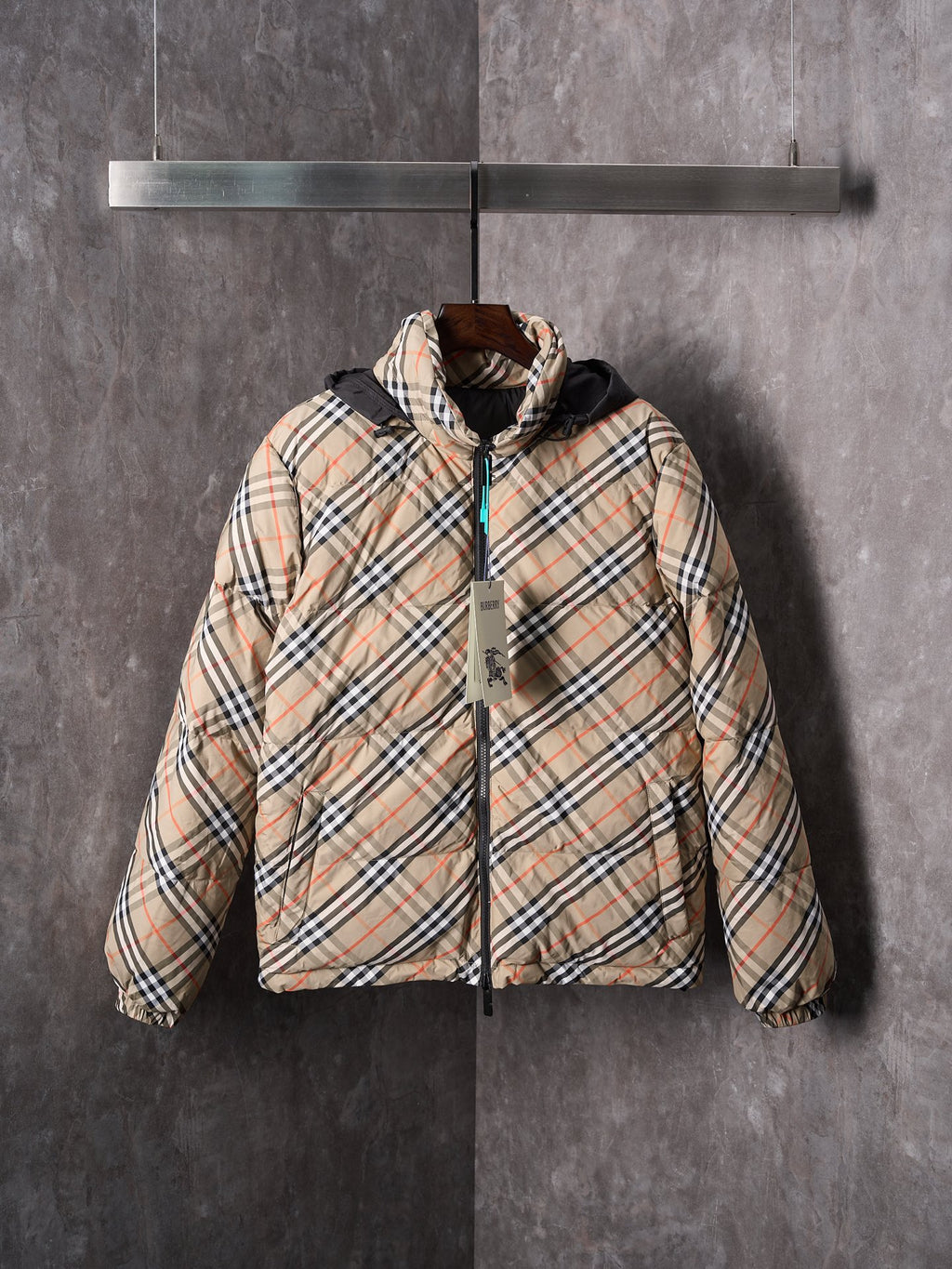 Plaid puffer jacket with black zip and hood, beige and multicolor check pattern.