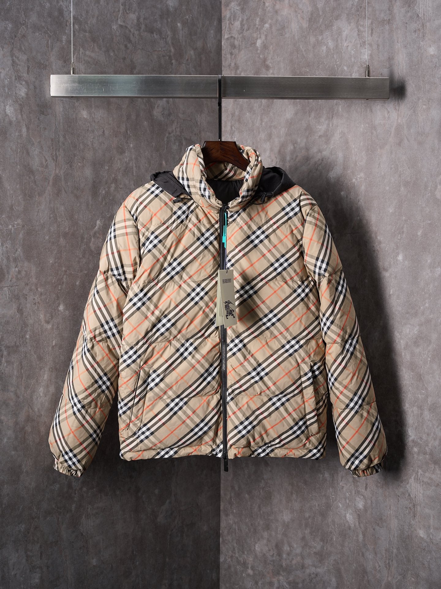 Plaid puffer jacket with black zip and hood, beige and multicolor check pattern.