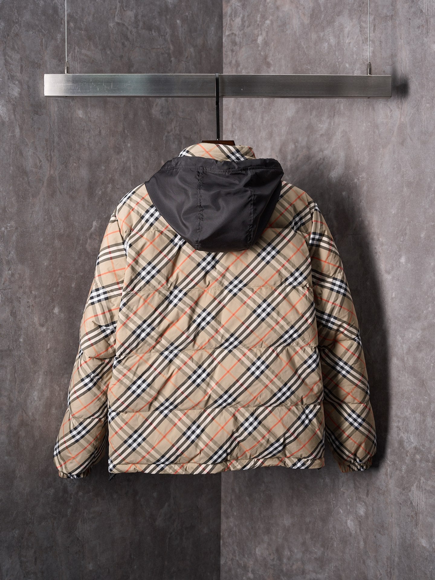 Plaid puffer jacket with black hood, rear view, beige and multicolor check pattern.