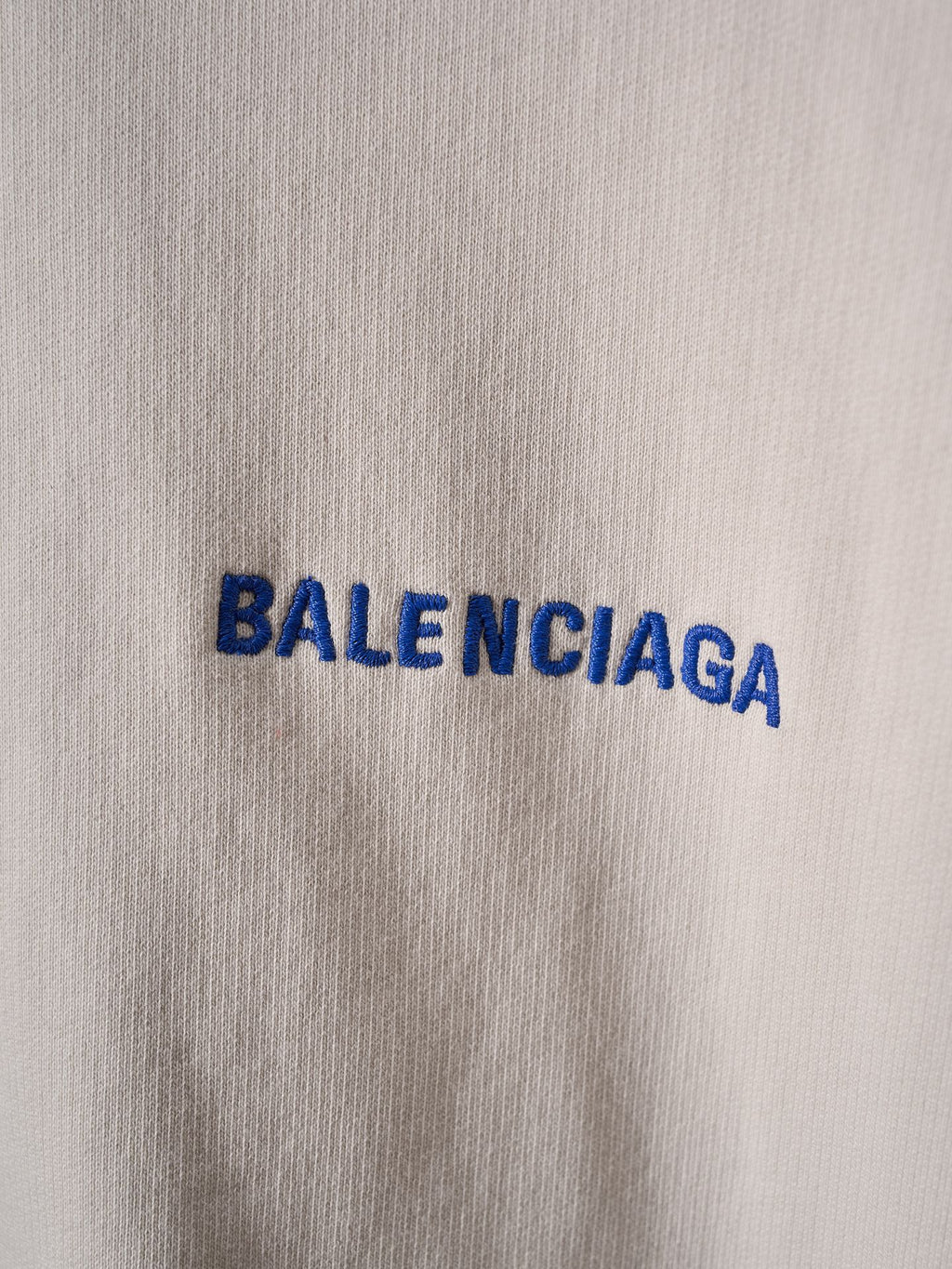 Off-white fabric close-up with blue BALENCIAGA lettering