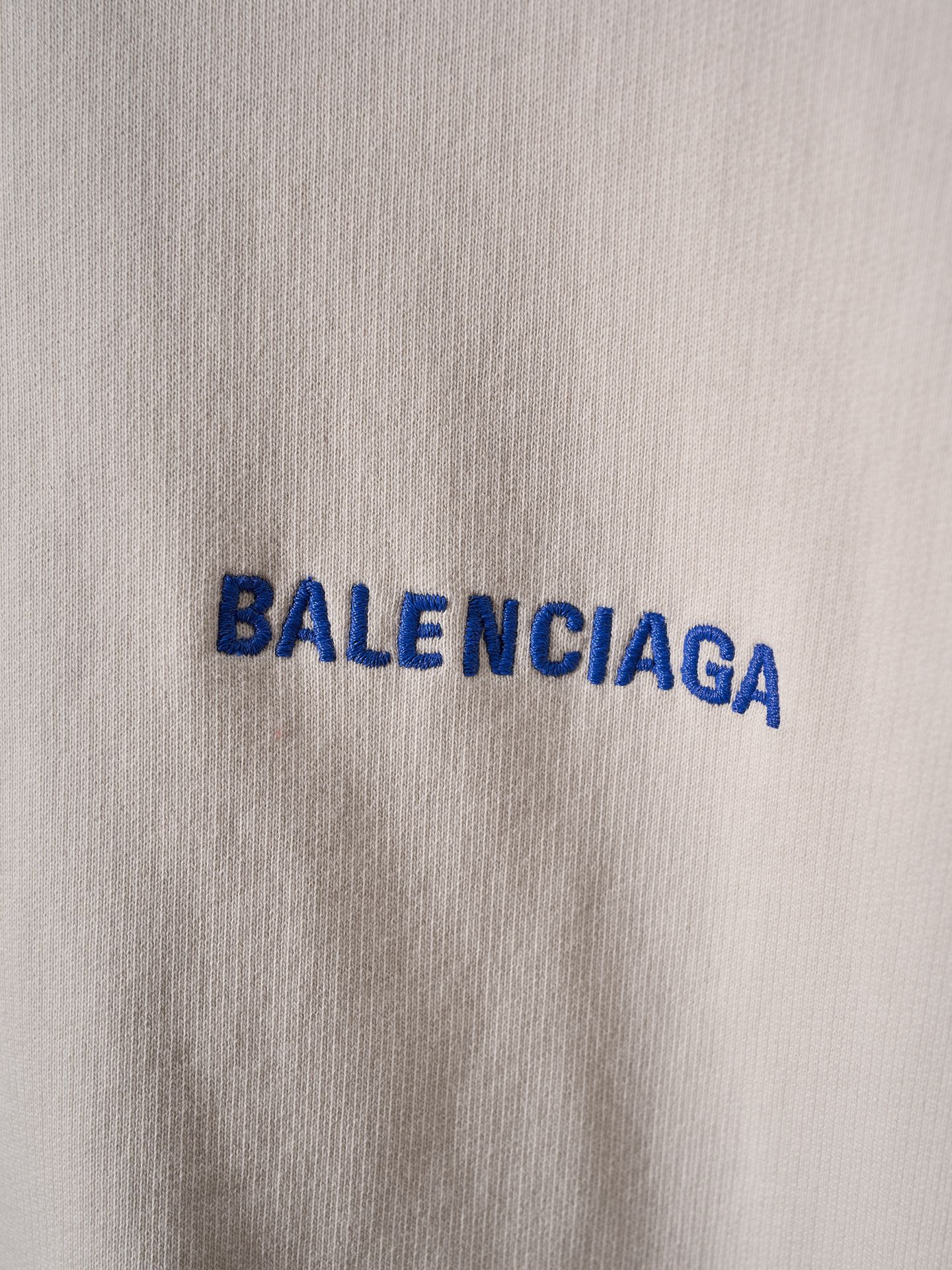 Off-white fabric close-up with blue BALENCIAGA lettering