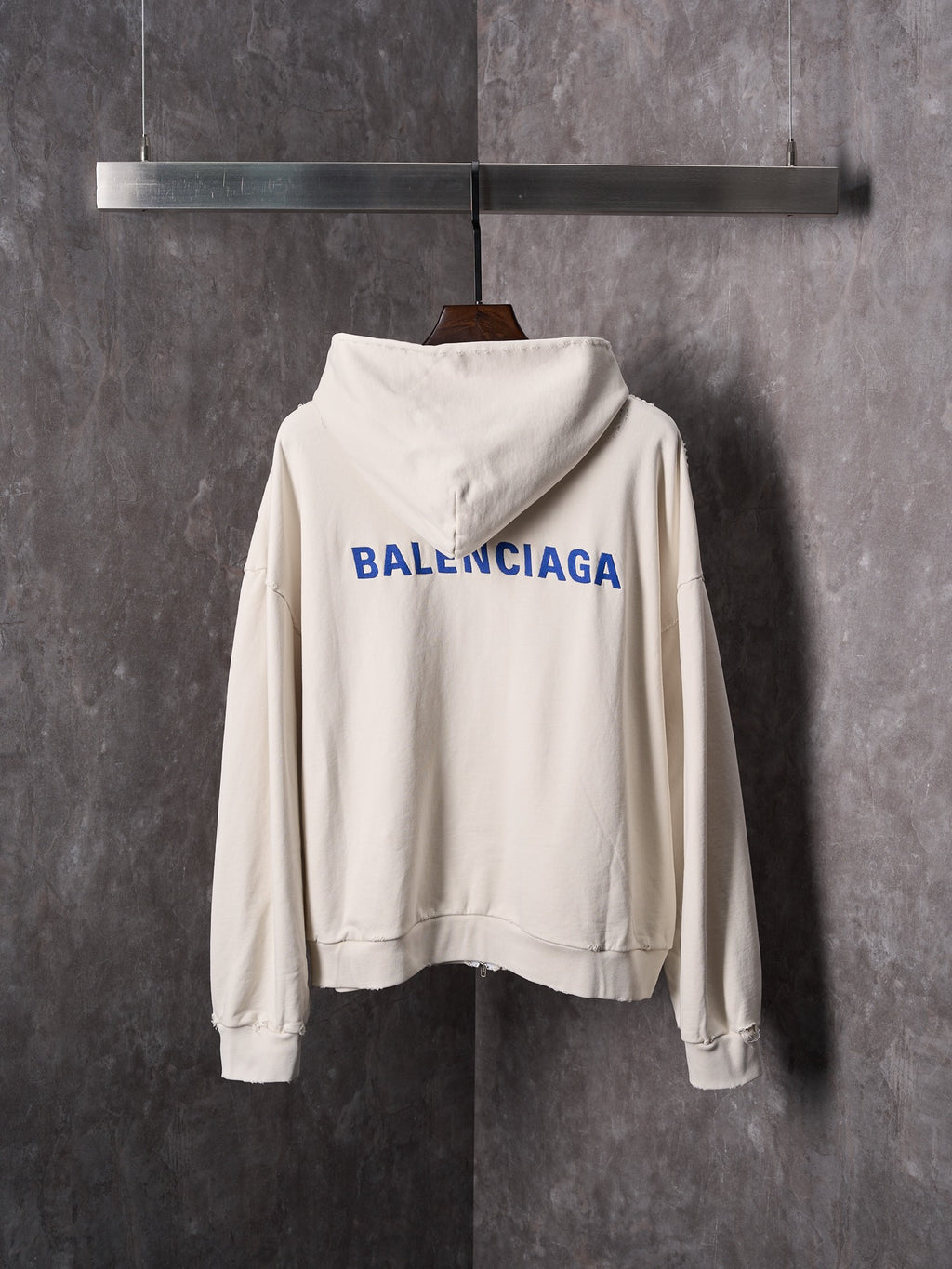 Off-white zip-up hoodie with hood and large Balenciaga logo on back