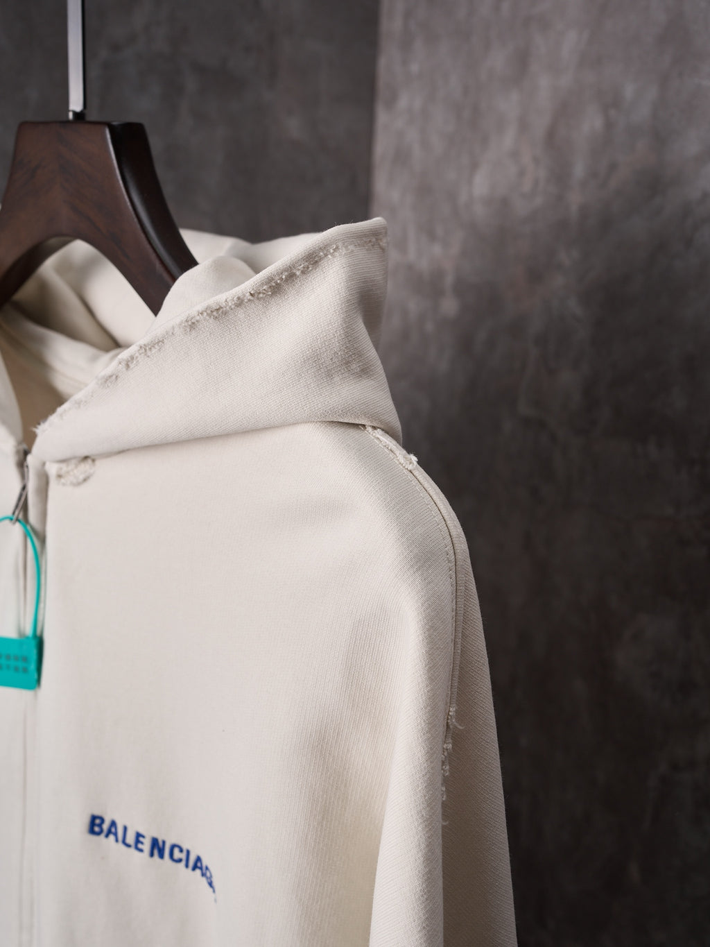 Off-white hoodie sleeve and shoulder area with blue Balenciaga logo