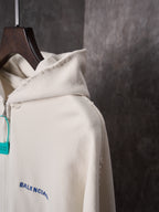 Off-white hoodie sleeve and shoulder area with blue Balenciaga logo