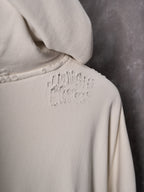Off-white hoodie back with small studded logo near hood seam