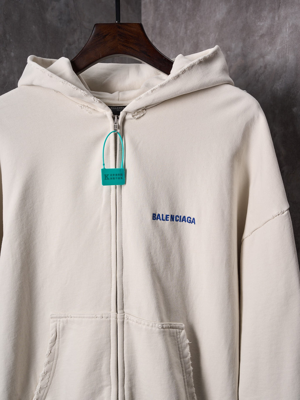 Off-white zip-up hoodie with hood, front pocket and Balenciaga logo patch