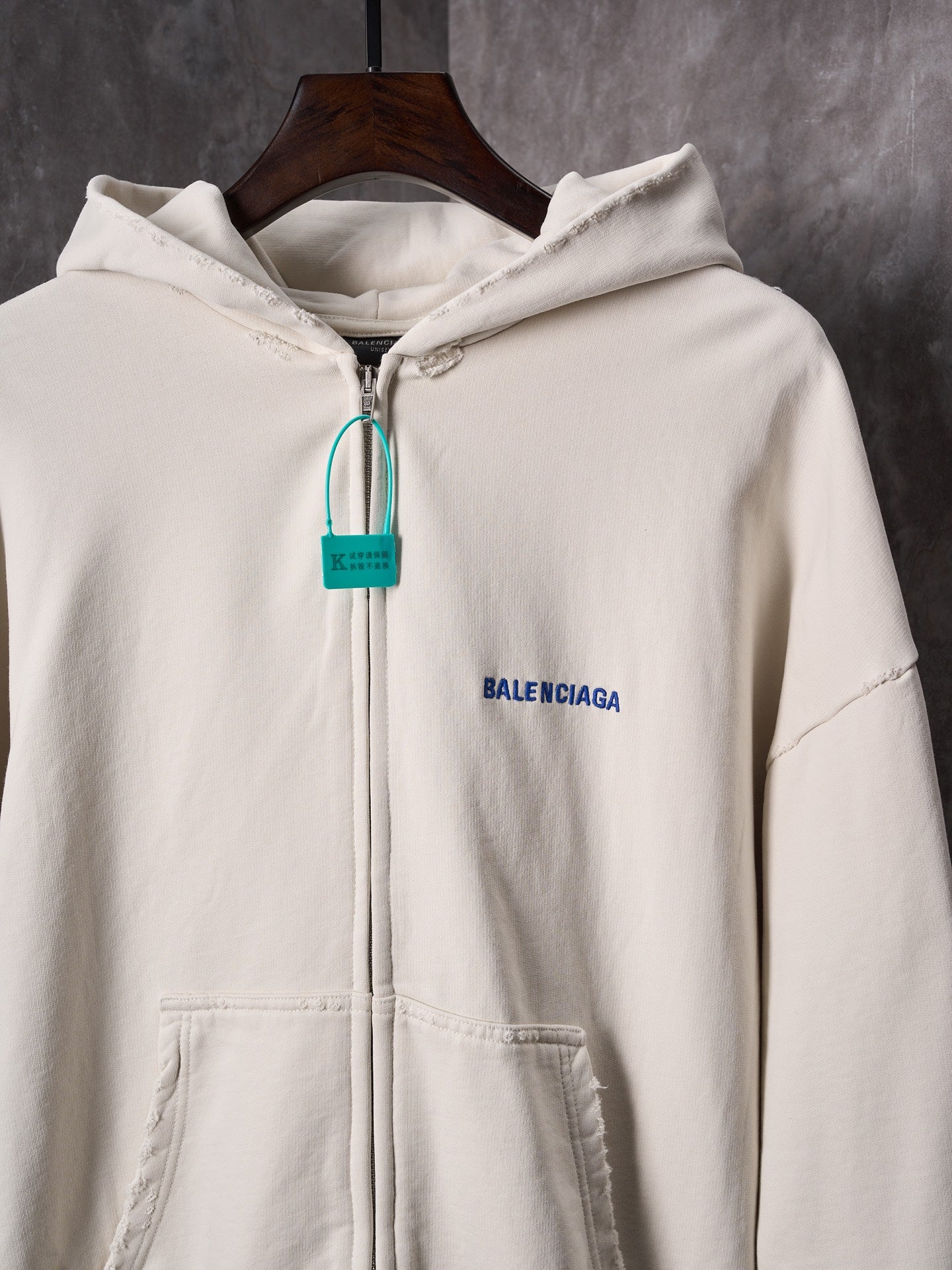 Off-white zip-up hoodie with hood, front pocket and Balenciaga logo patch