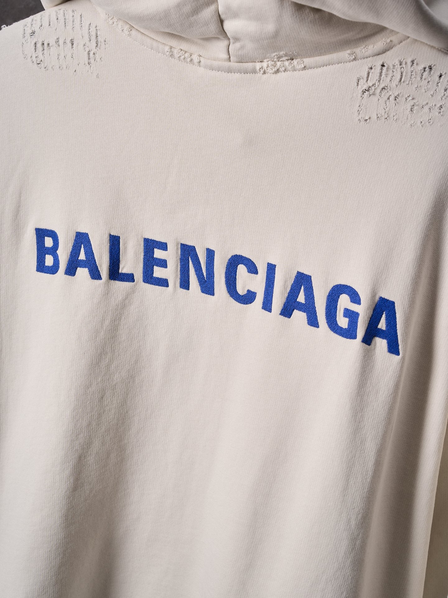 Off-white hoodie chest with large blue BALENCIAGA lettering