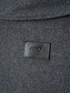 Long dark Fendi garment with FENDI logo label at chest
