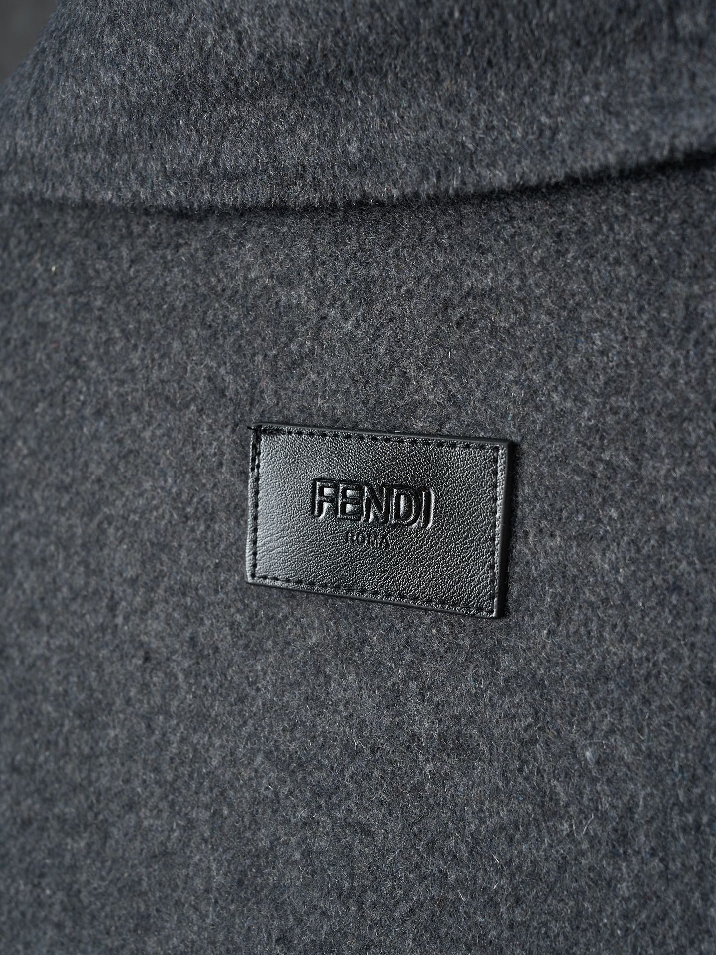 Long dark Fendi garment with FENDI logo label at chest