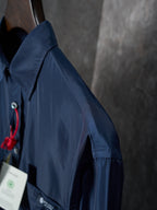 Navy Prada long-sleeve shirt side view with shoulder seam and red cord tag