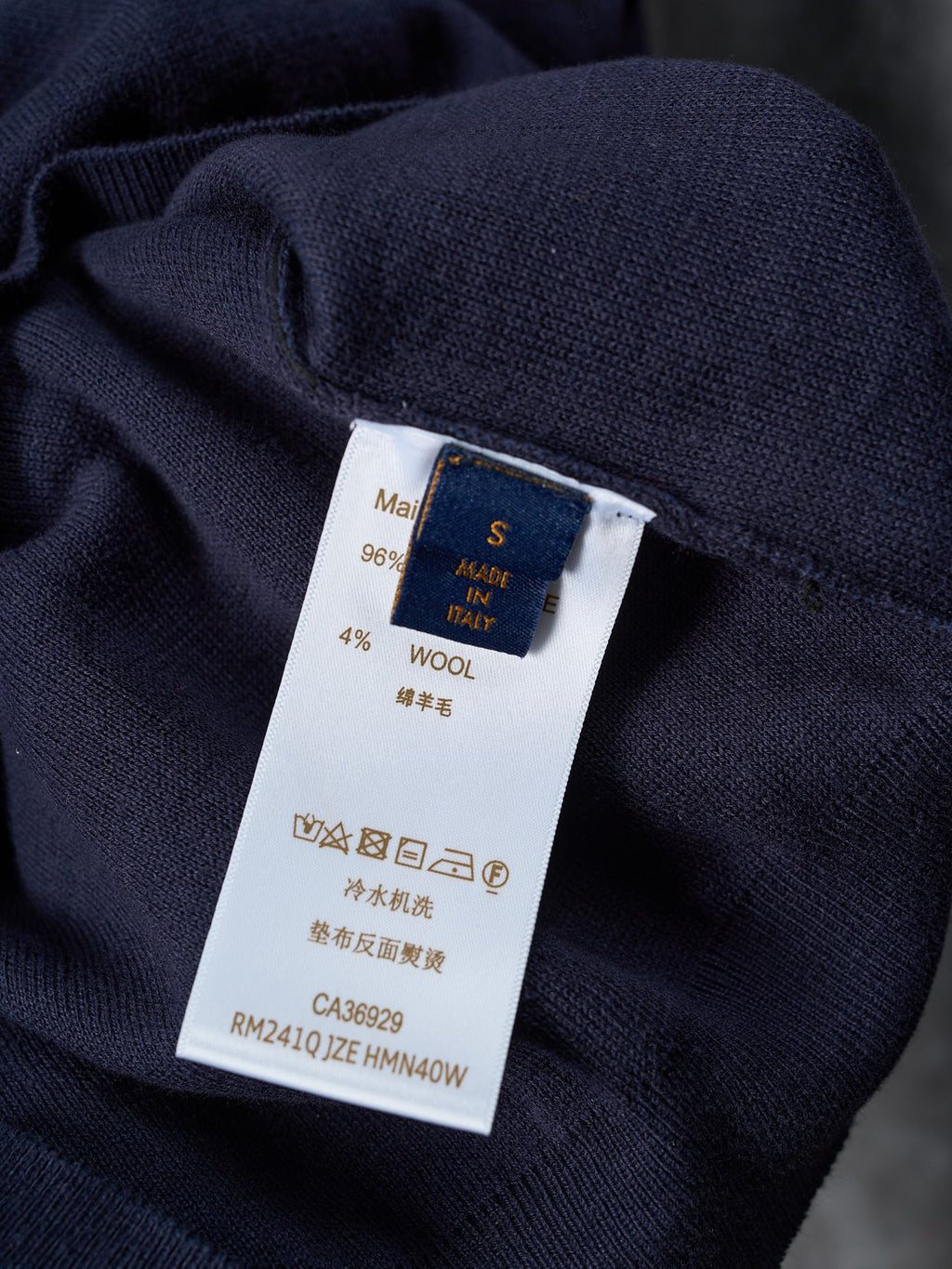 Inside-care label on dark navy knit sweater with wool and washing symbols