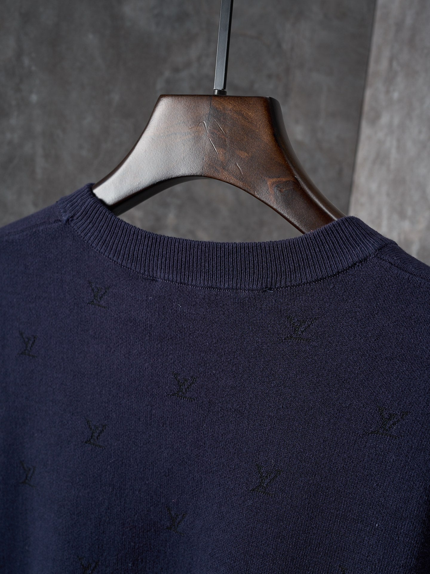 Dark navy knit sweater neckline with subtle allover logo pattern