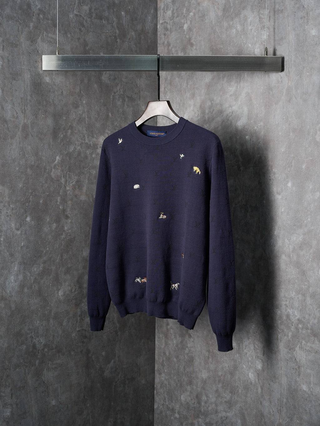 Long-sleeve knit sweater in dark navy with scattered animal logo embroidery