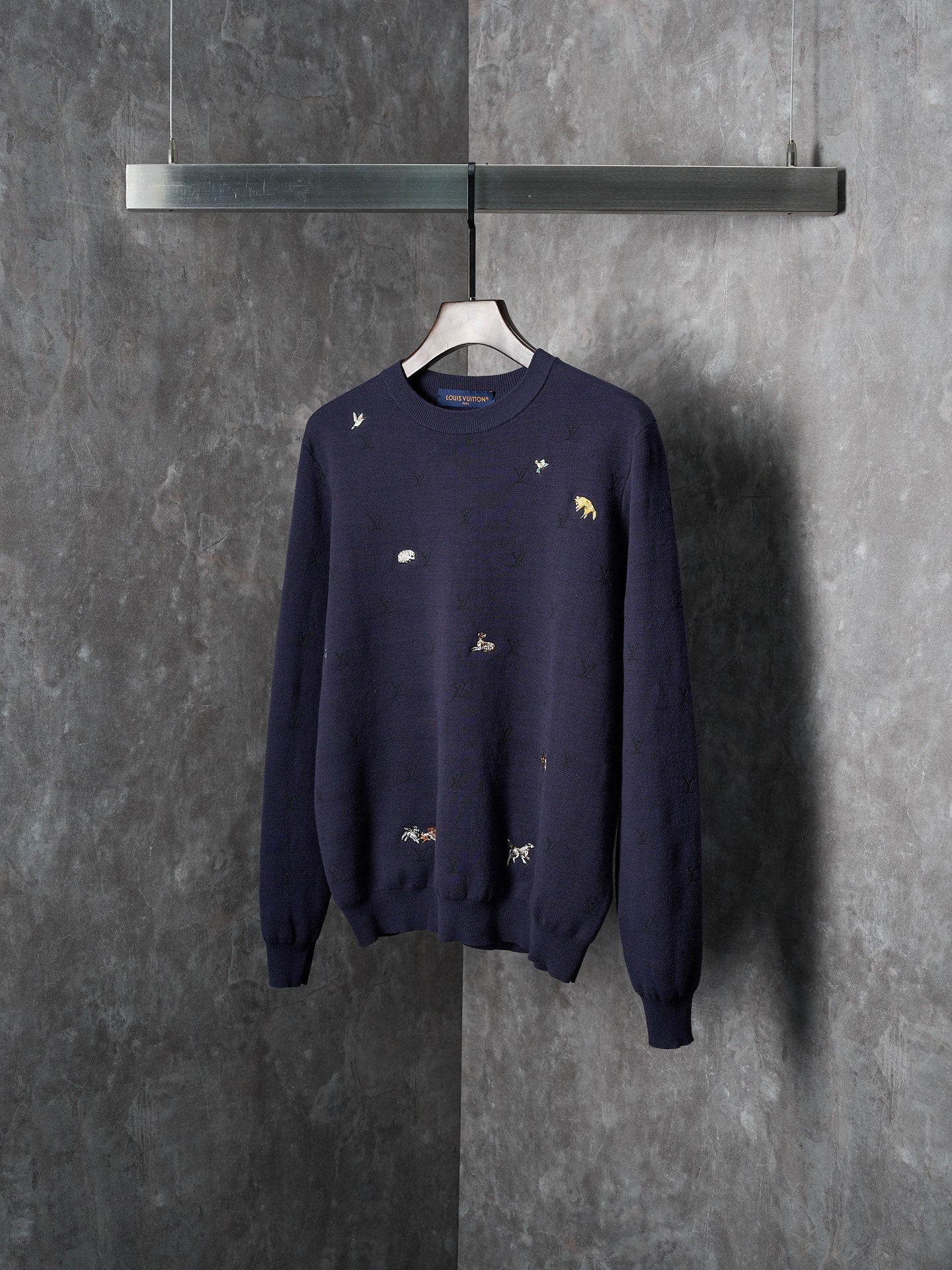 Long-sleeve knit sweater in dark navy with scattered animal logo embroidery