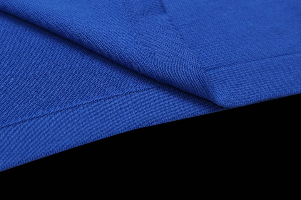 Blue T-shirt fabric close-up with folded seam and texture