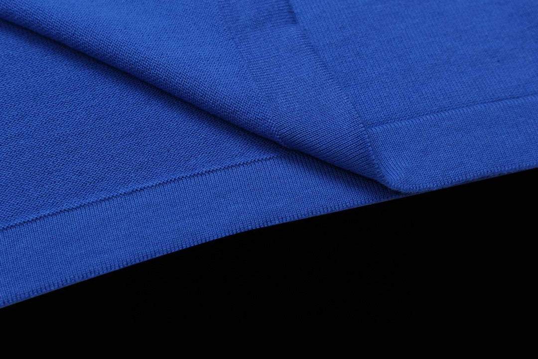 Blue T-shirt fabric close-up with folded seam and texture