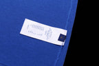 Blue T-shirt with white size label and small blue brand tag