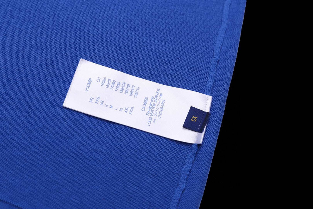Blue T-shirt with white size label and small blue brand tag