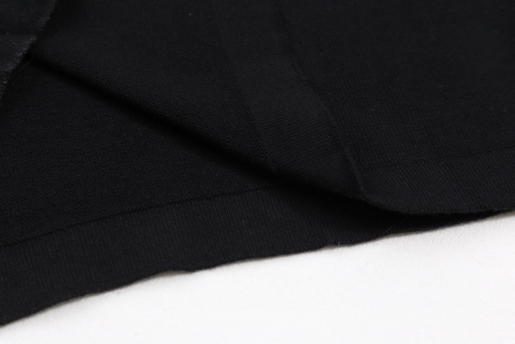 Black T-shirt fabric with visible seam and fold