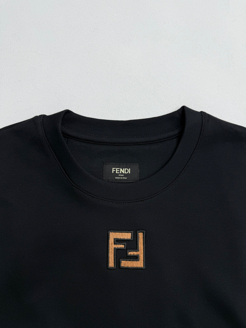 Fendi crew-neck T-shirt close-up with FENDI logo patch at neckline