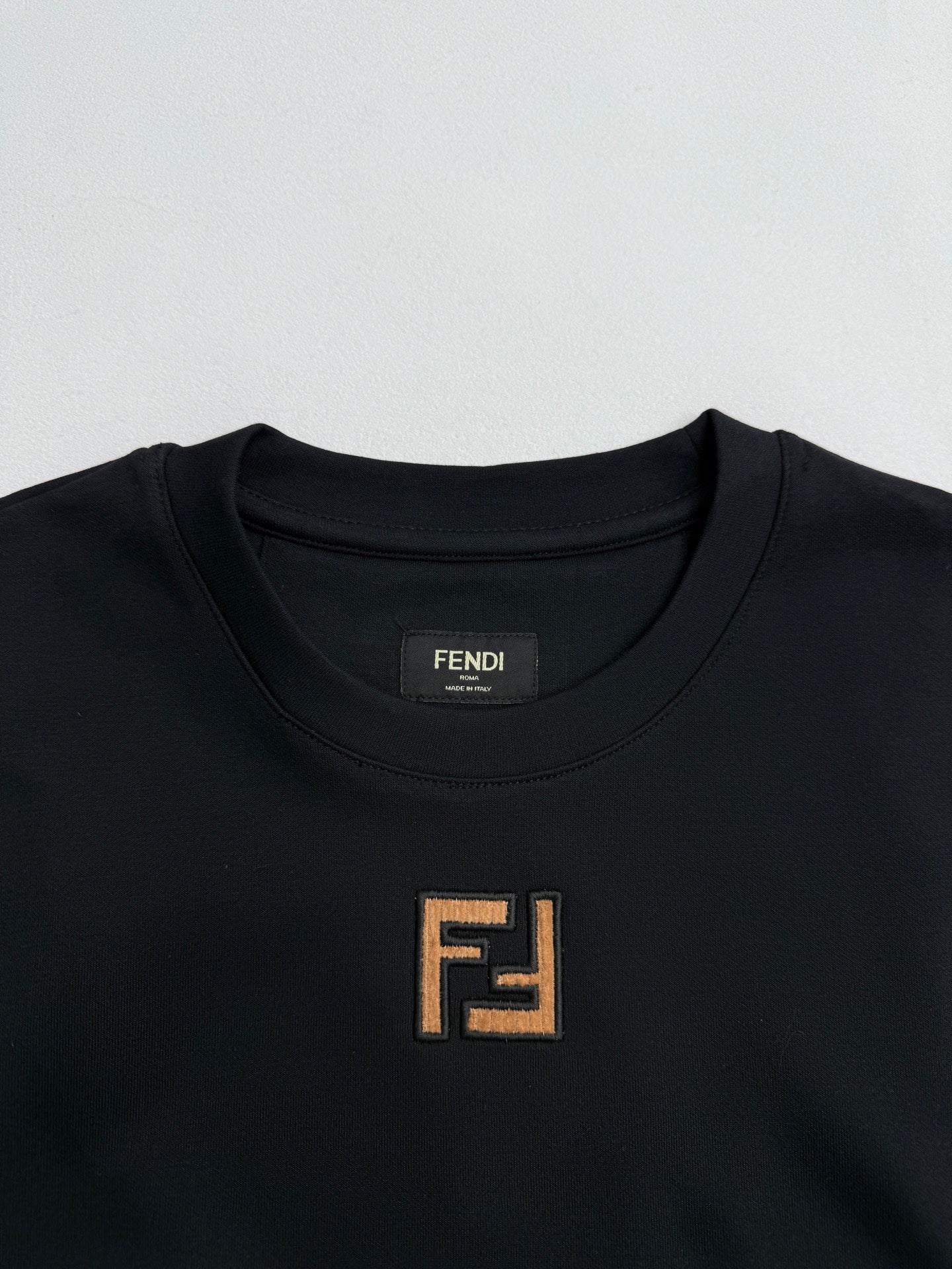 Fendi crew-neck T-shirt close-up with FENDI logo patch at neckline