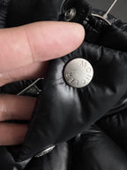 Moncler puffer jacket fabric detail with snap button and metal logo stamp