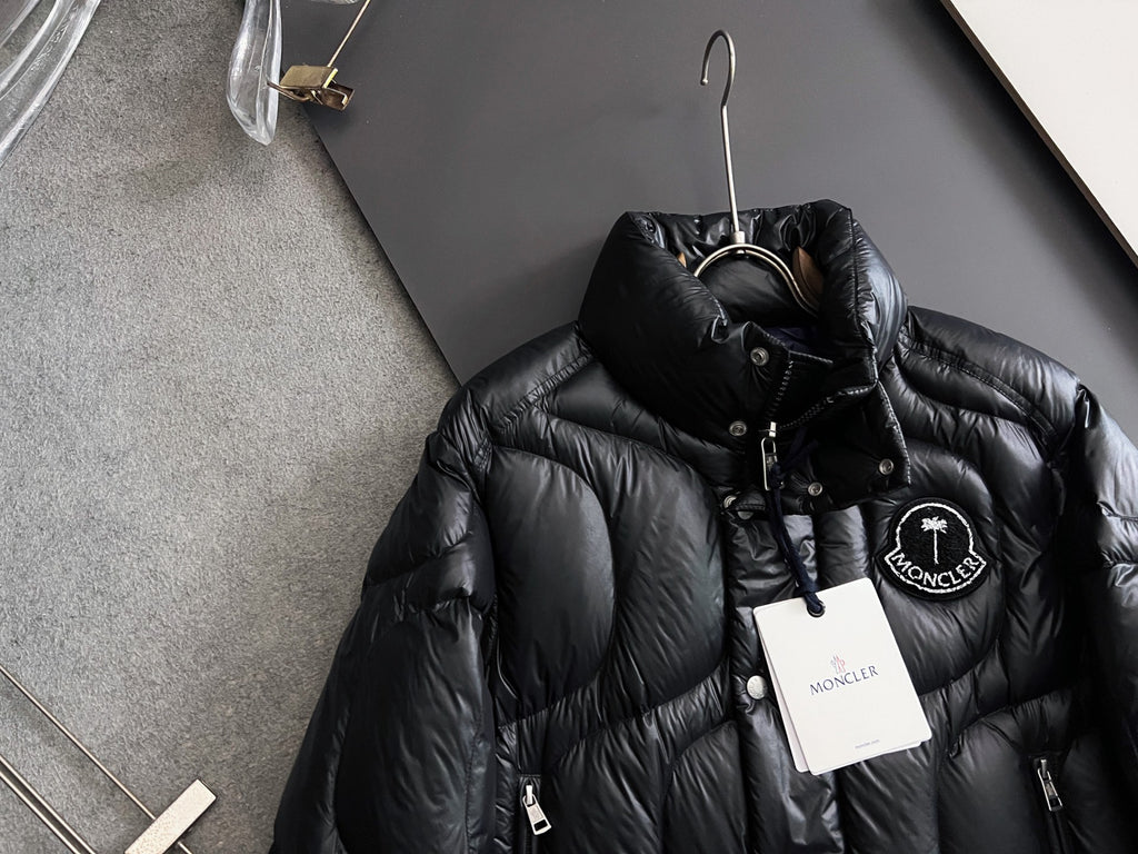 Moncler long puffer jacket, black with stand collar, drawstring, and logo badge