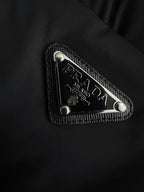 Prada triangle logo patch with textured border on black puffer fabric
