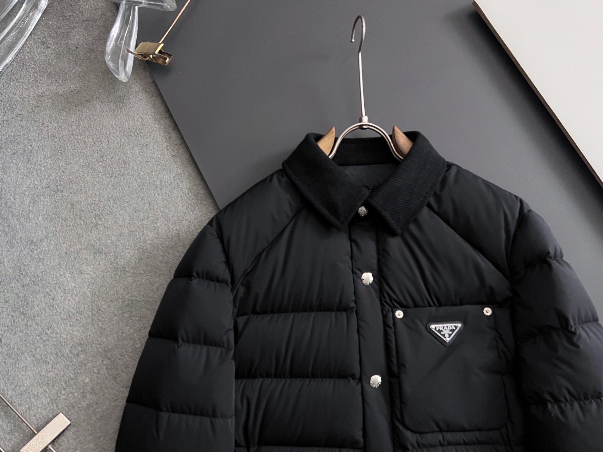 Prada long black puffer jacket front view with stand collar and triangle chest logo