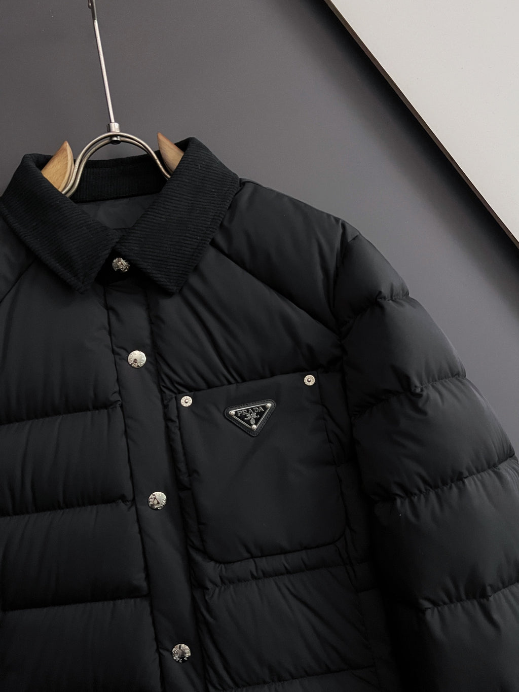 Prada long black puffer jacket collar and triangle logo patch on chest