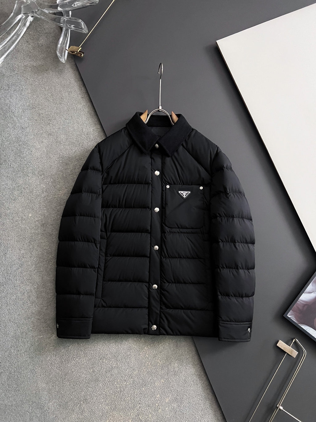 Prada long black puffer jacket with stand collar and front buttons, chest triangle logo
