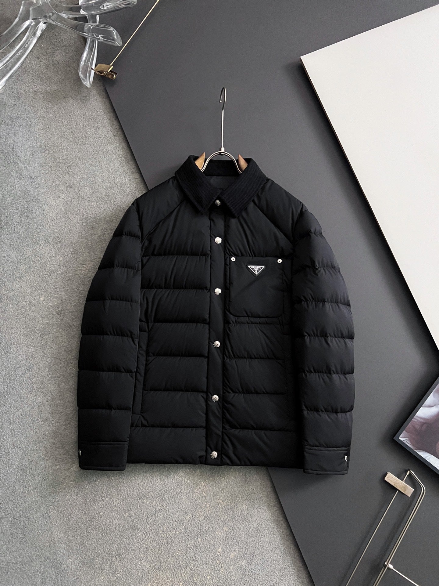 Prada long black puffer jacket with stand collar and front buttons, chest triangle logo