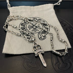 Silver-tone layered necklaces with dagger charms on fabric pouch