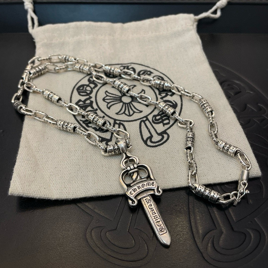 Silver-tone layered necklaces with dagger charms on fabric pouch
