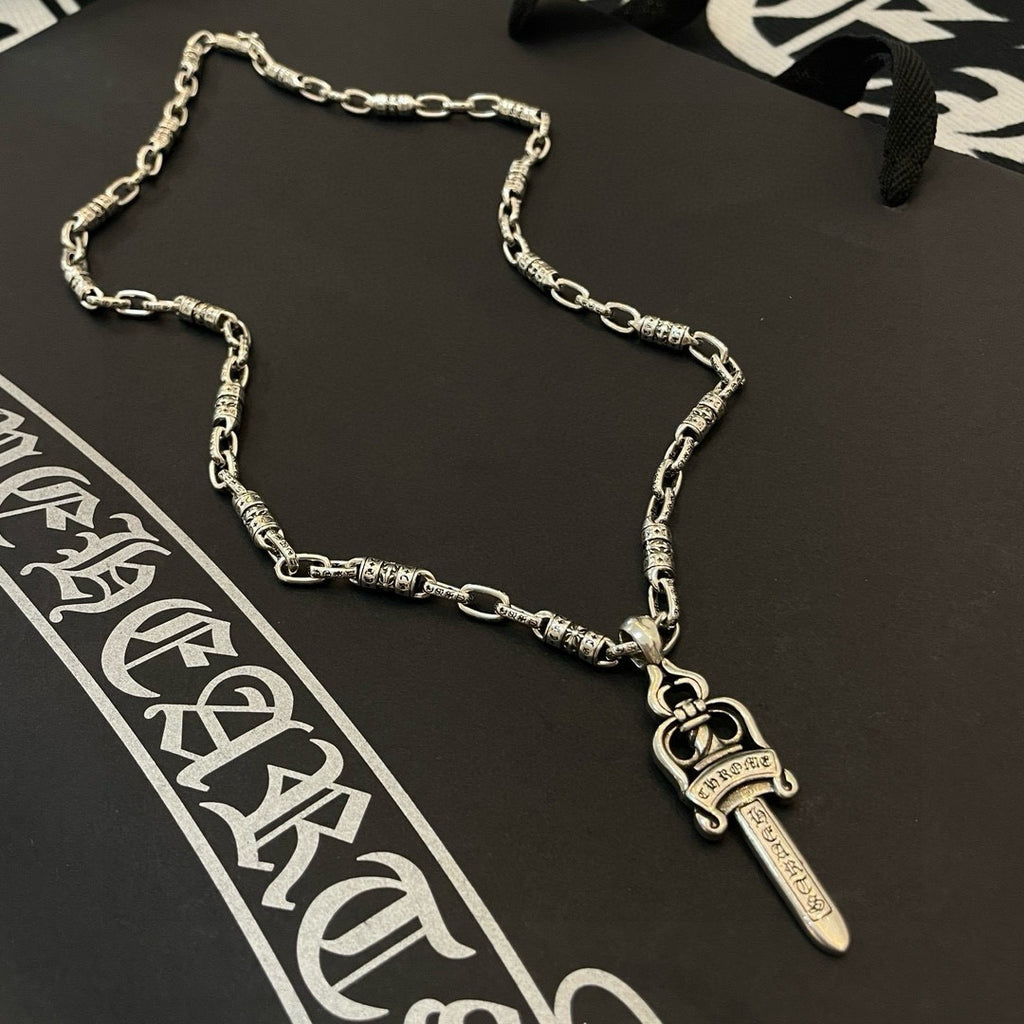 Silver-tone necklace with engraved links and dagger pendant charm