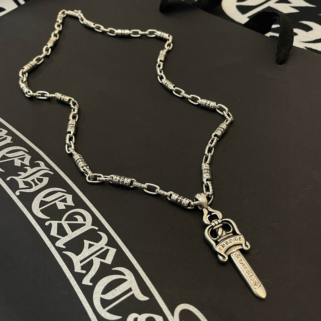Silver-tone necklace with engraved links and dagger pendant charm