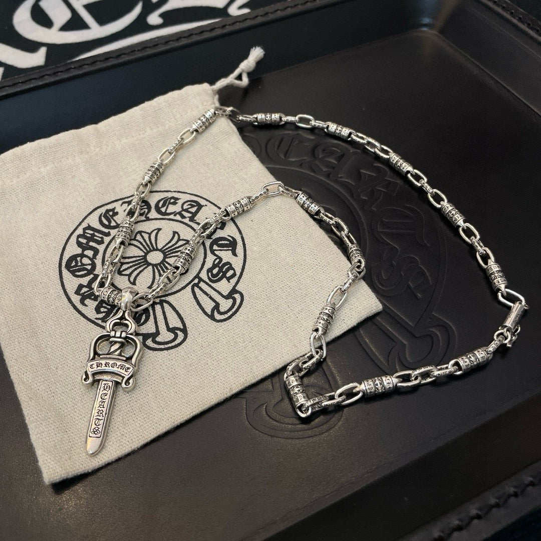 Silver-tone necklace with dagger charm pendant on pouch and box