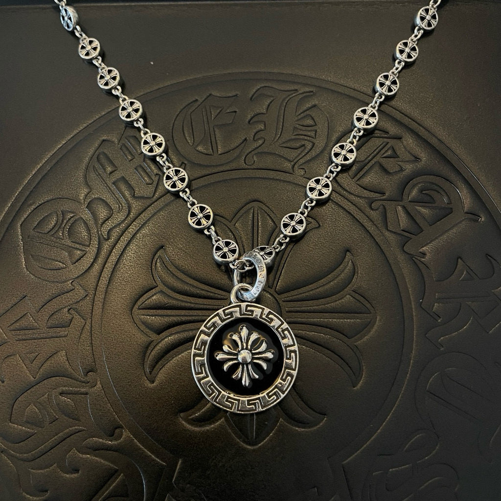 Silver round pendant necklace with Greek key border and flower emblem center